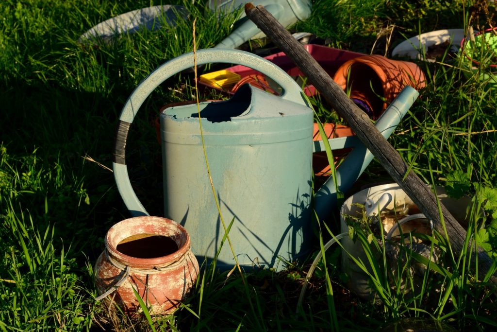 white and brown watering can on green grass